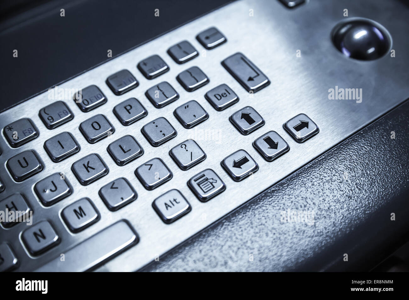 Industrial keyboard made of steel with trackball. Blue toned photo, selective focus with shallow DOF Stock Photo