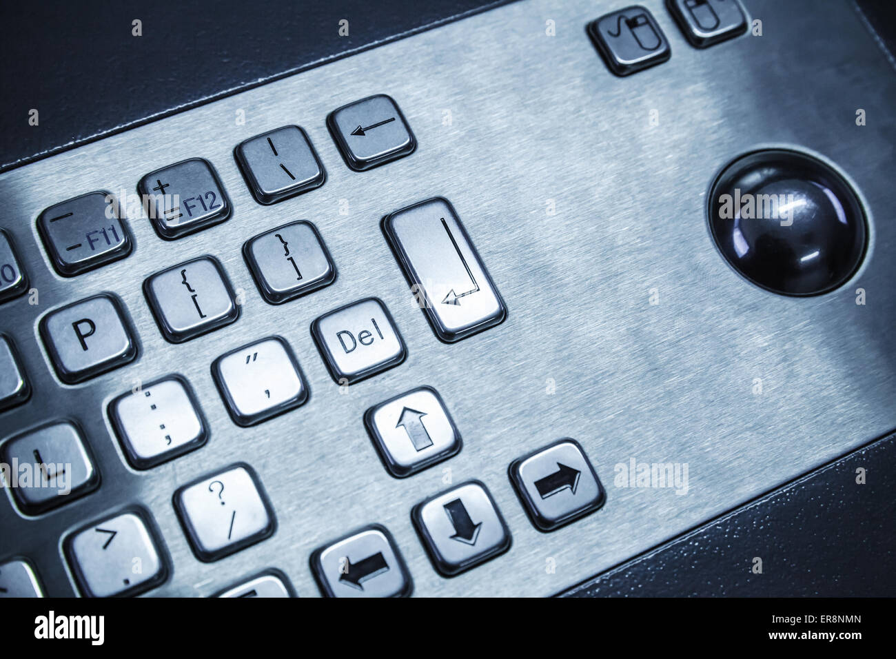 Industrial keyboard made of steel with a trackball, blue toned photo, selective focus with shallow DOF Stock Photo