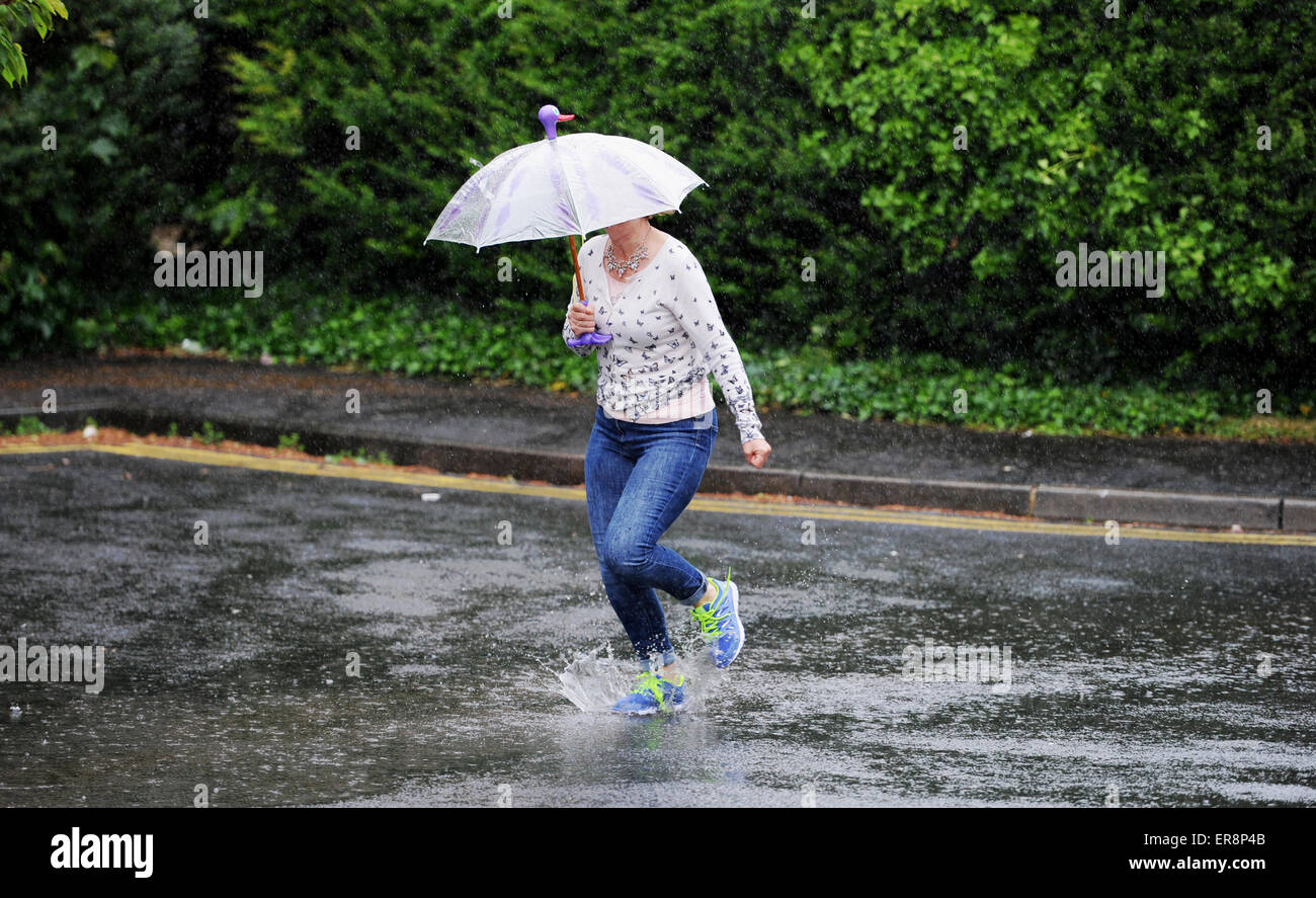 Brighton UK 26th May 2015 - A woman gets caught in torrential rain as she runs across a street in Brighton today with wet and windy weather forecast for the south east this afternoon Credit:  Simon Dack/Alamy Live News Stock Photo