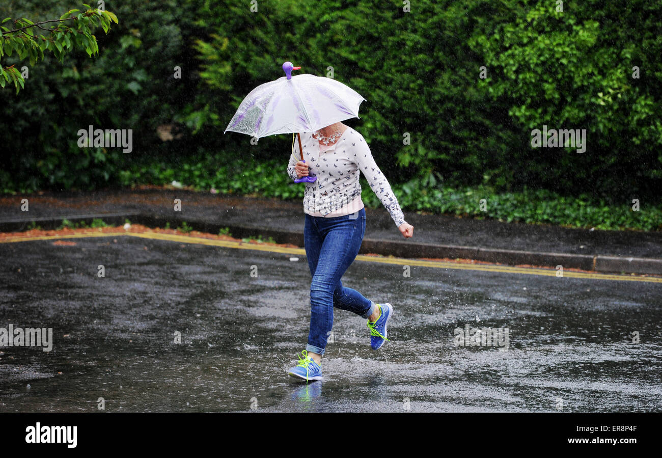 Brighton UK 26th May 2015 - A woman gets caught in torrential rain as she runs across a street in Brighton today with wet and windy weather forecast for the south east this afternoon Credit:  Simon Dack/Alamy Live News Stock Photo