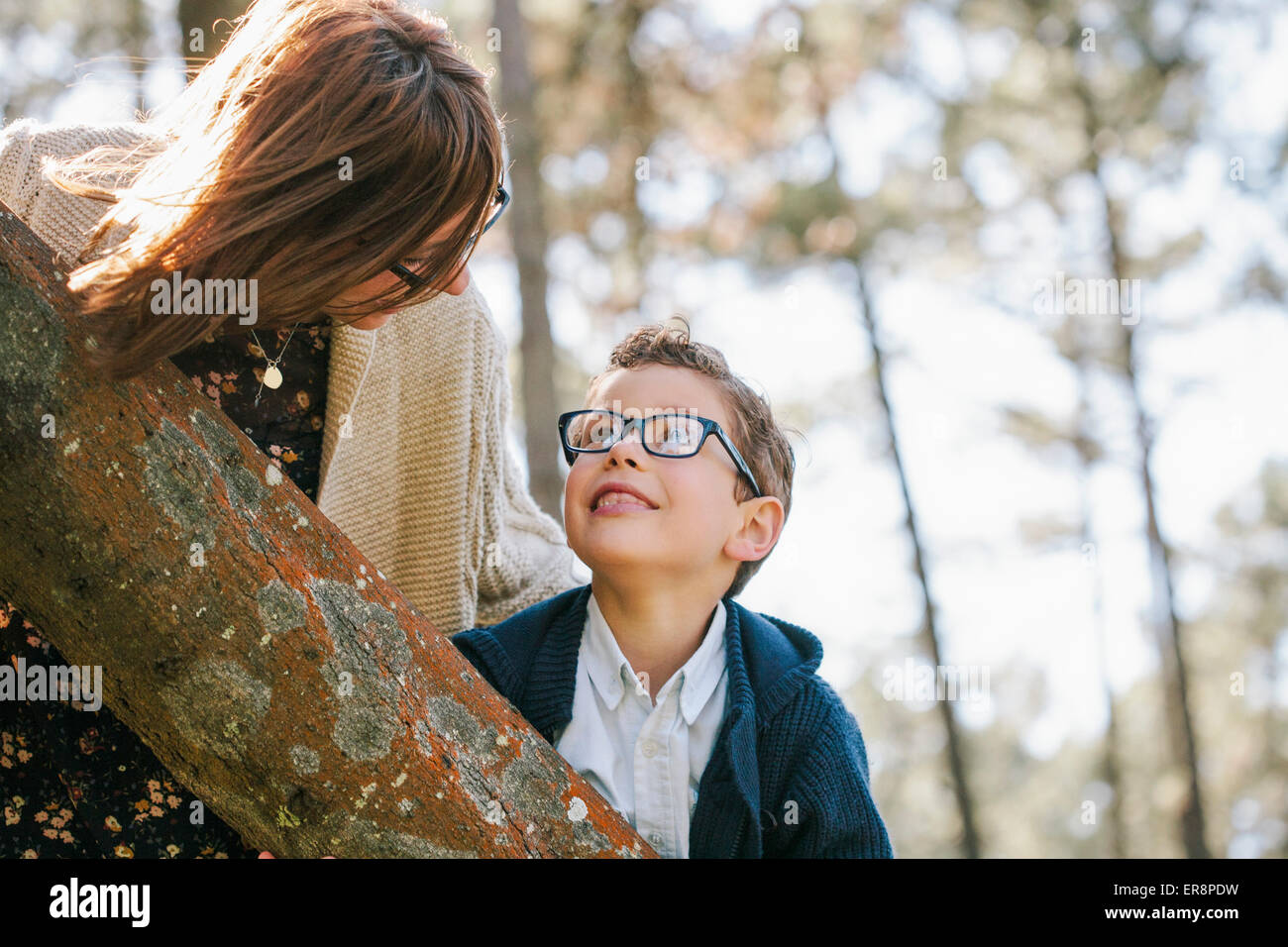 Loving mother and son looking at each other in forest Stock Photo