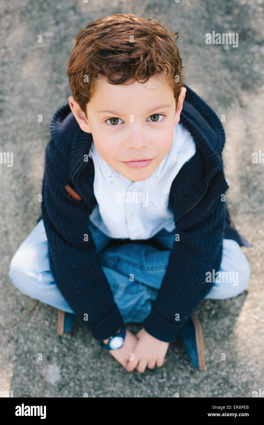 High angle portrait of boy sitting on street Stock Photo - Alamy