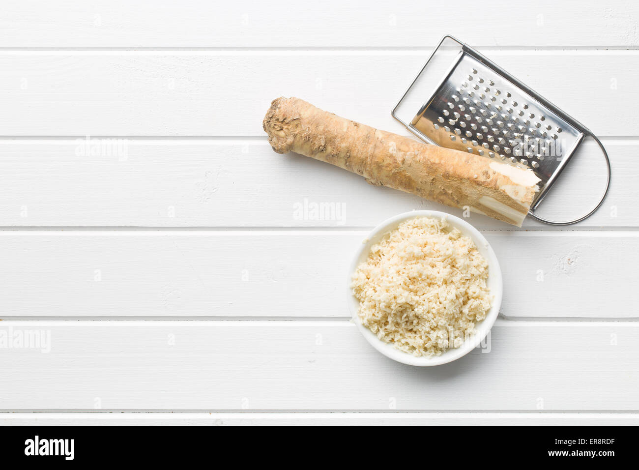grated horseradish root on kitchen table Stock Photo