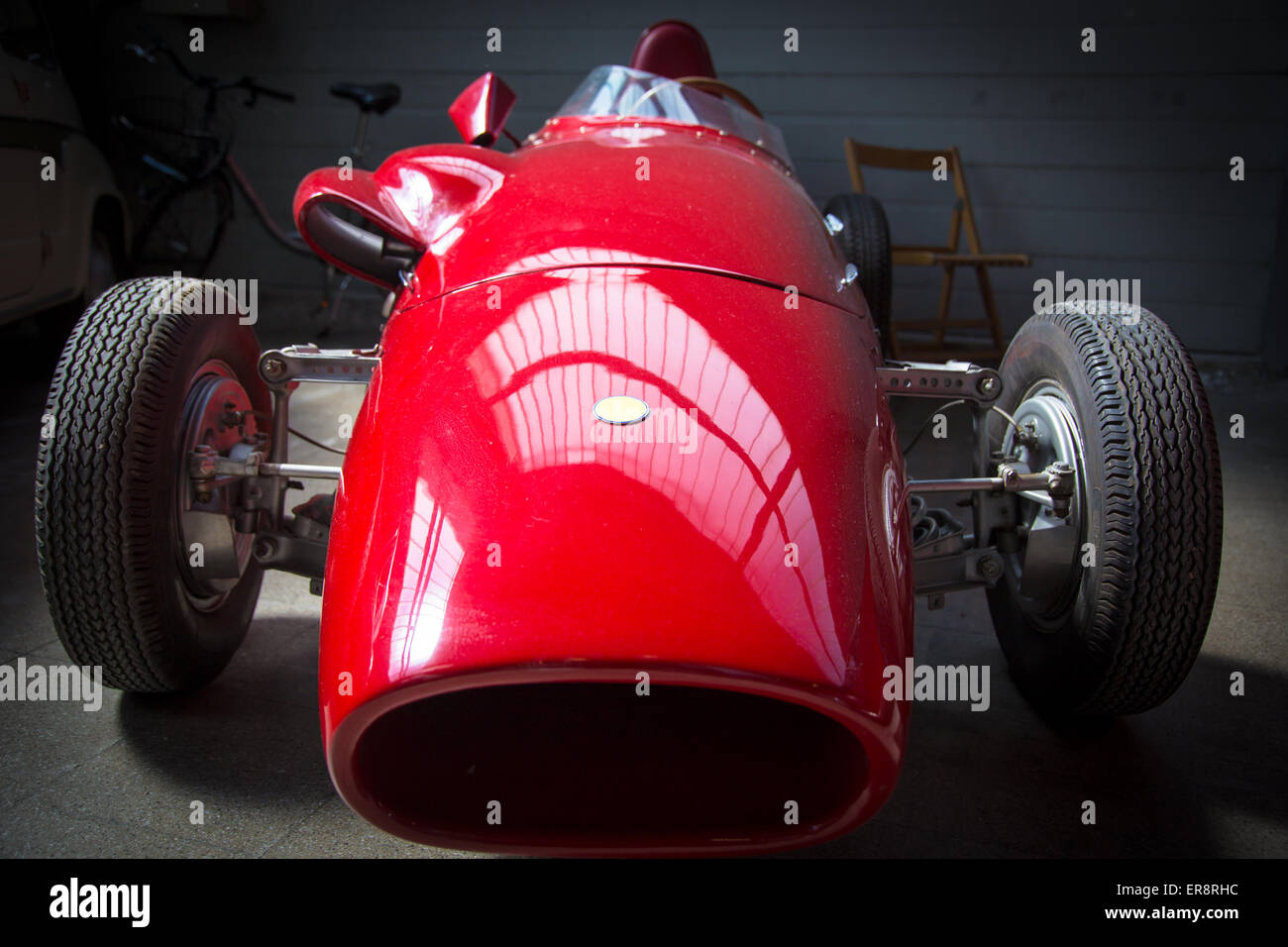 old fashioned red racing car parked in a garage Stock Photo
