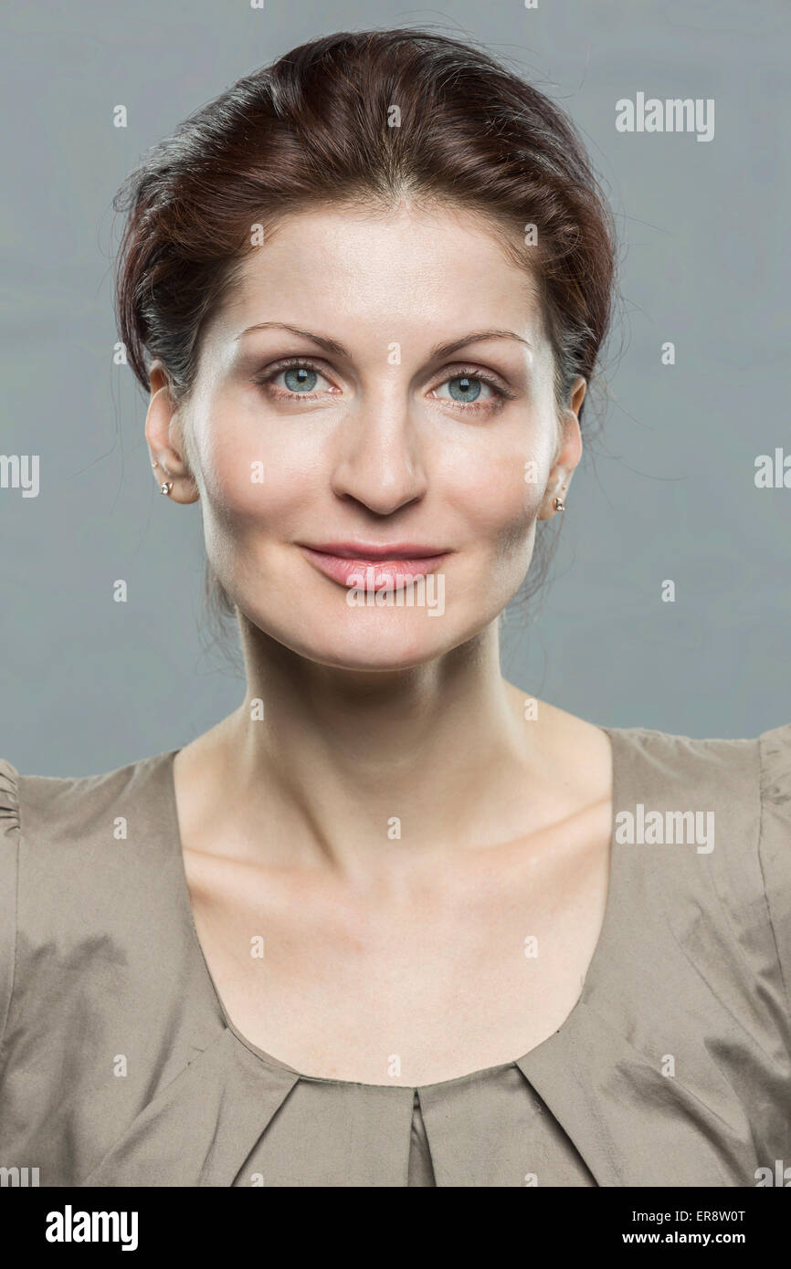 Portrait of smiling mid adult woman against gray background Stock Photo