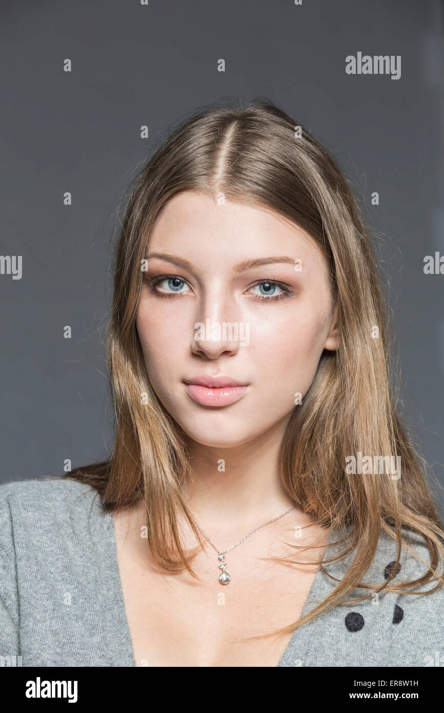 Portrait of beautiful young woman against gray background Stock Photo ...