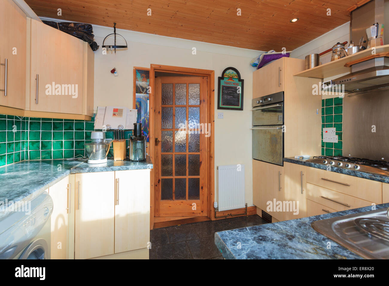 small modern style kitchen in english with timber clad ceiling Stock Photo