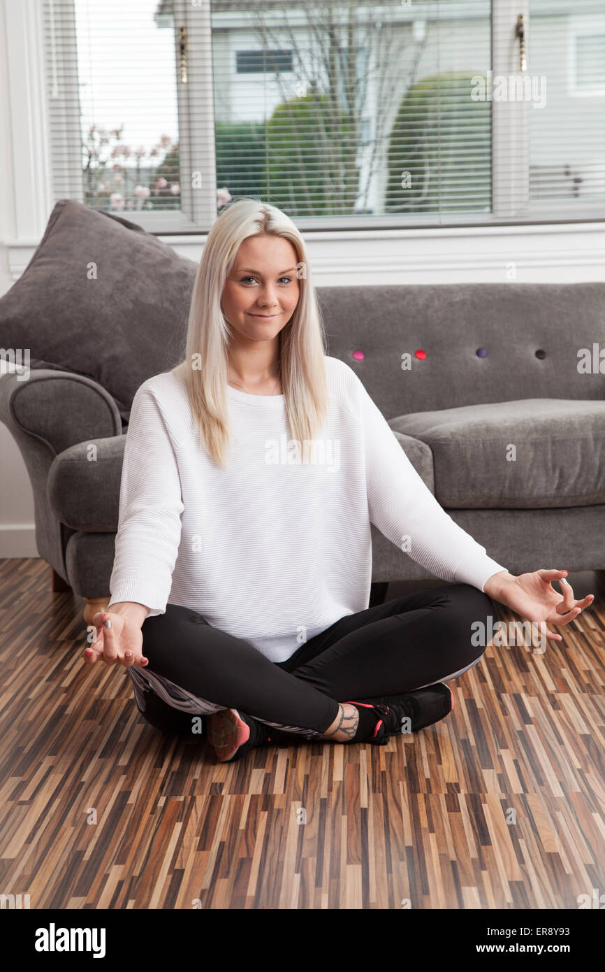 Young woman practicing yoga at home. Stock Photo