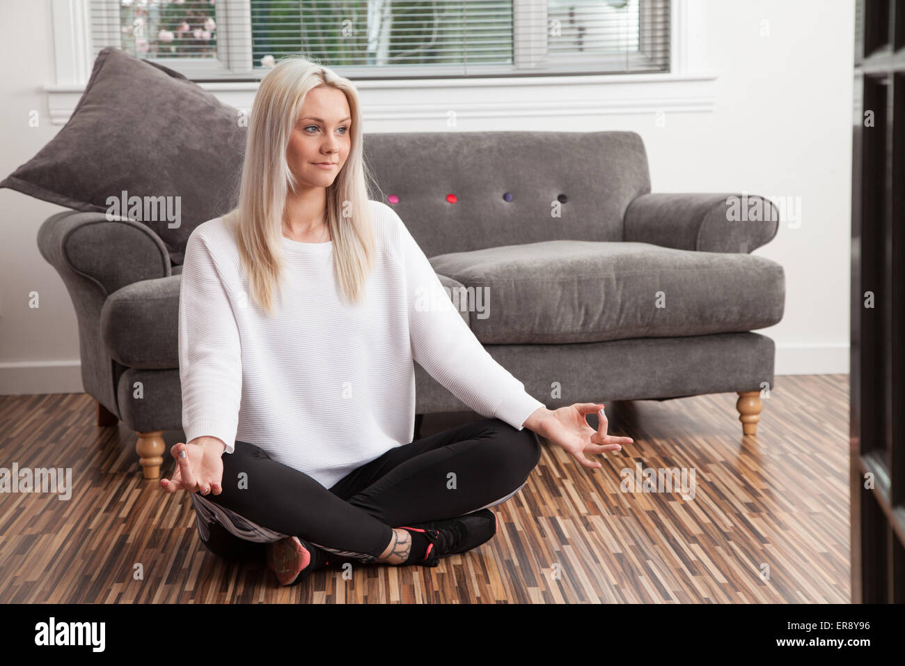 Young woman practicing yoga at home. Stock Photo