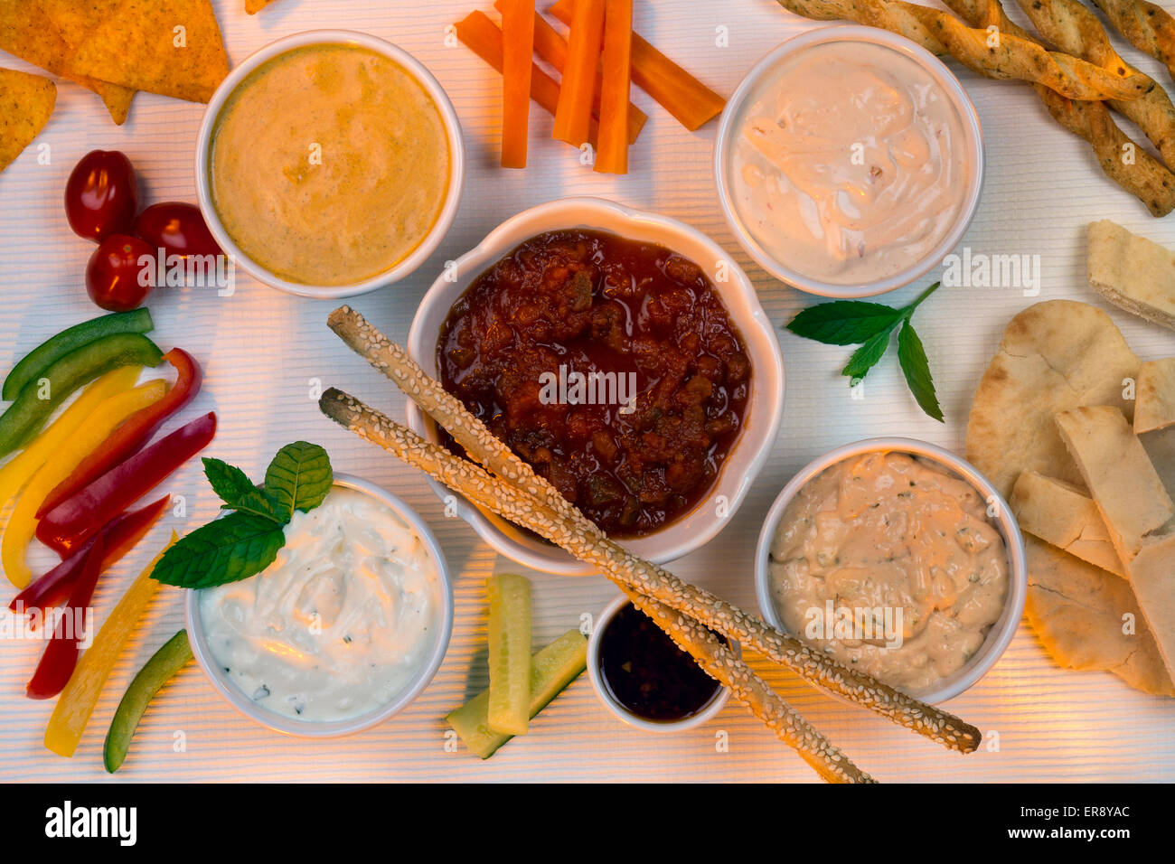A selection of party dips with bread sticks, pita bread and other