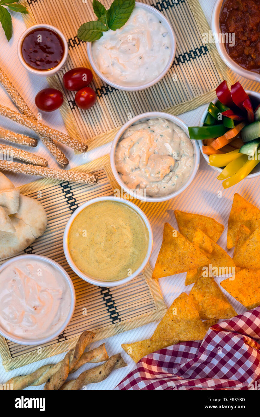 A selection of party dips with bread sticks, pita bread and other
