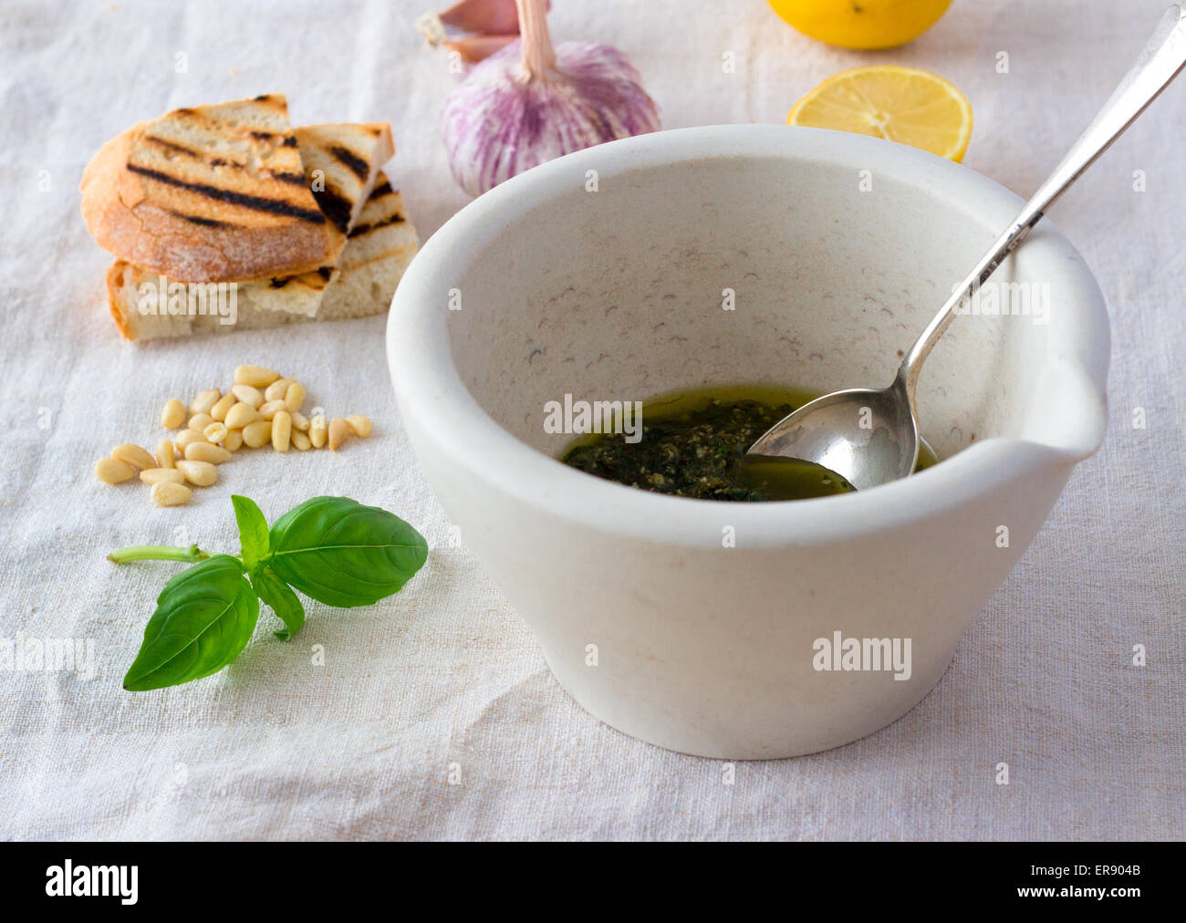 Pesto in mortar and pestle with ingredients Stock Photo Alamy