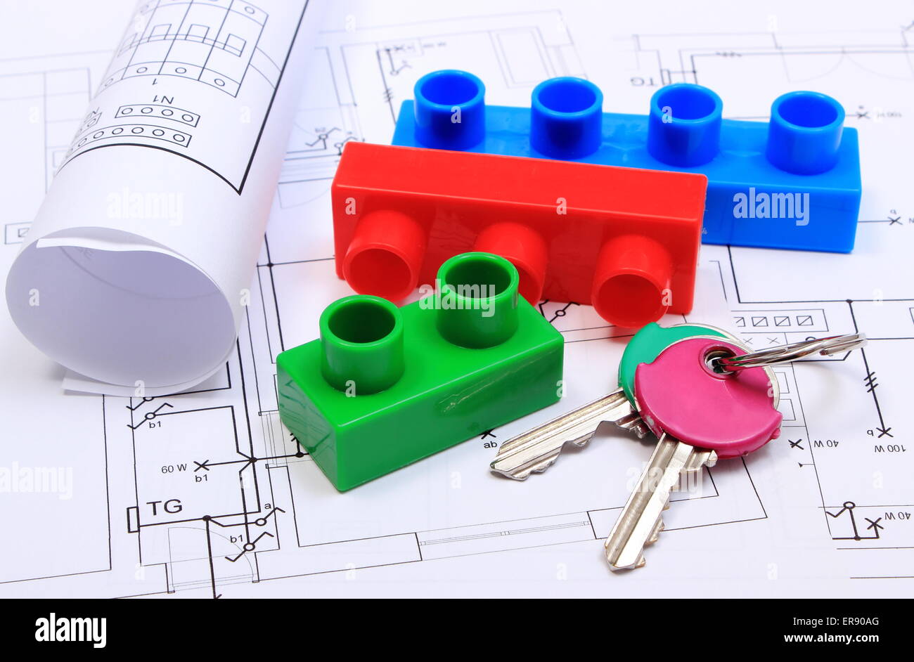 Home keys, plastic building blocks and rolled electrical diagrams lying on construction drawing of house, Stock Photo