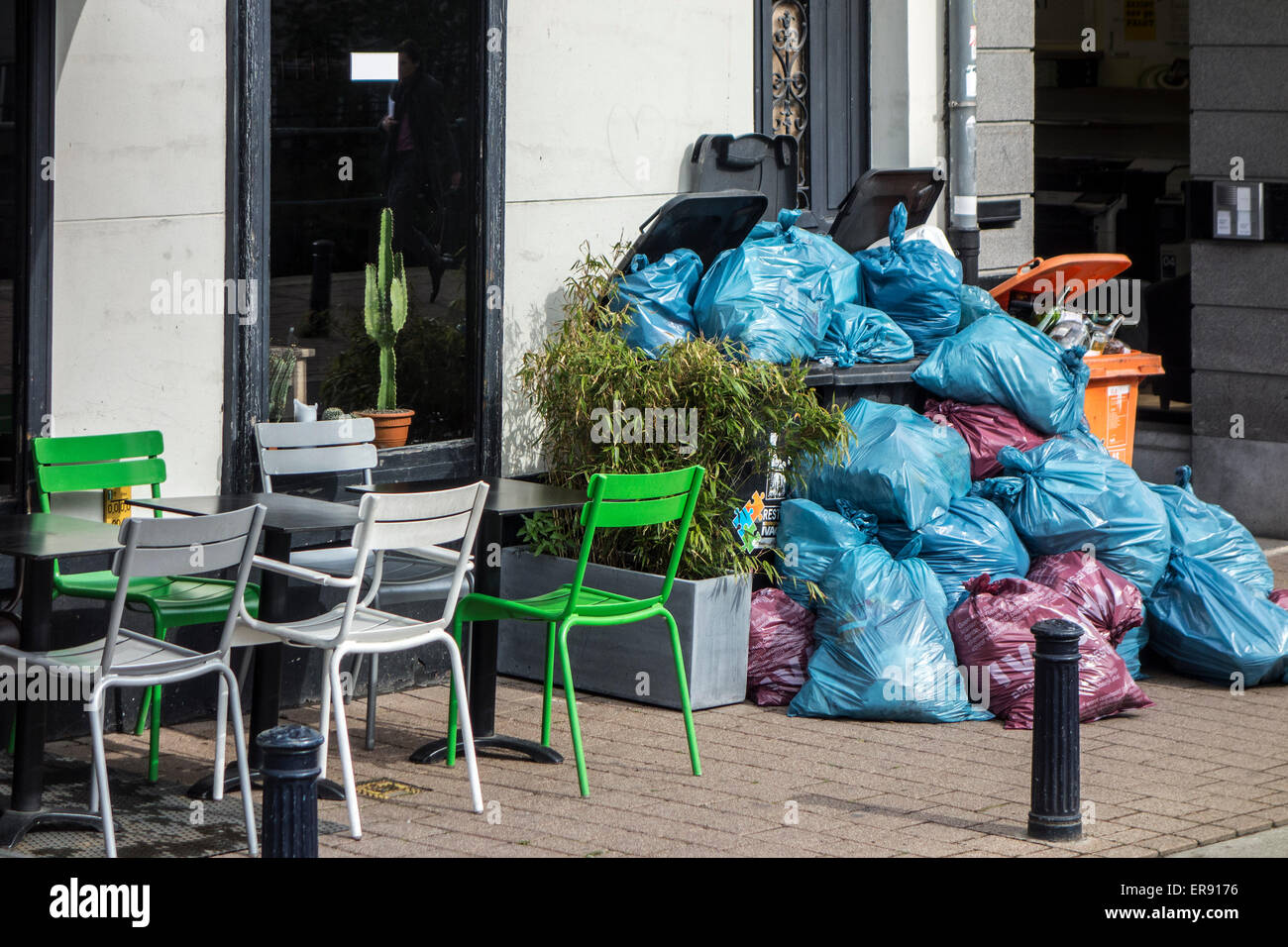 Rubbish bags and garbage containers with piled up household refuse blocking pavement due to strike by waste processing firm Stock Photo