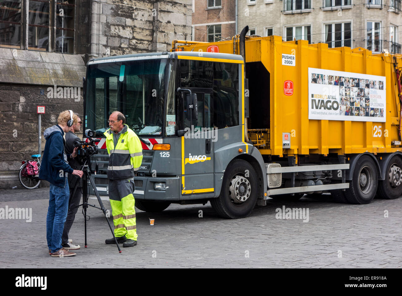 Refuse collector of waste processing firm IVAGO giving interview to camera crew about strike in the city Ghent, Belgium Stock Photo