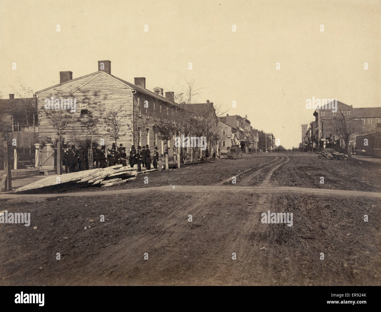 Former residence of President Lincoln, birthplace of Robt. Lincoln. Photograph shows men wearing suits and top hats standing on the side of the road at the end of a row of buildings at or near the site of the Globe Tavern in Springfield, Illinois. Date 18 Stock Photo
