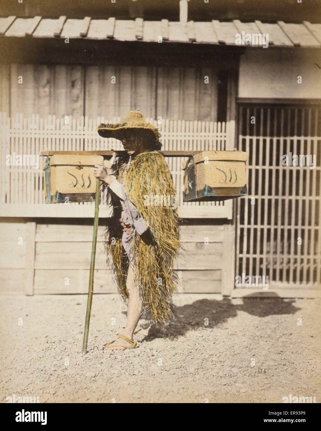 Porter wearing protective outer garments made of straw. Photograph