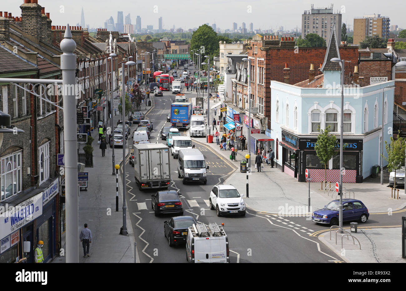 Traffic congestion on Lee Bridge Road, a busy suburban high street in North London. London city skyline in the background Stock Photo