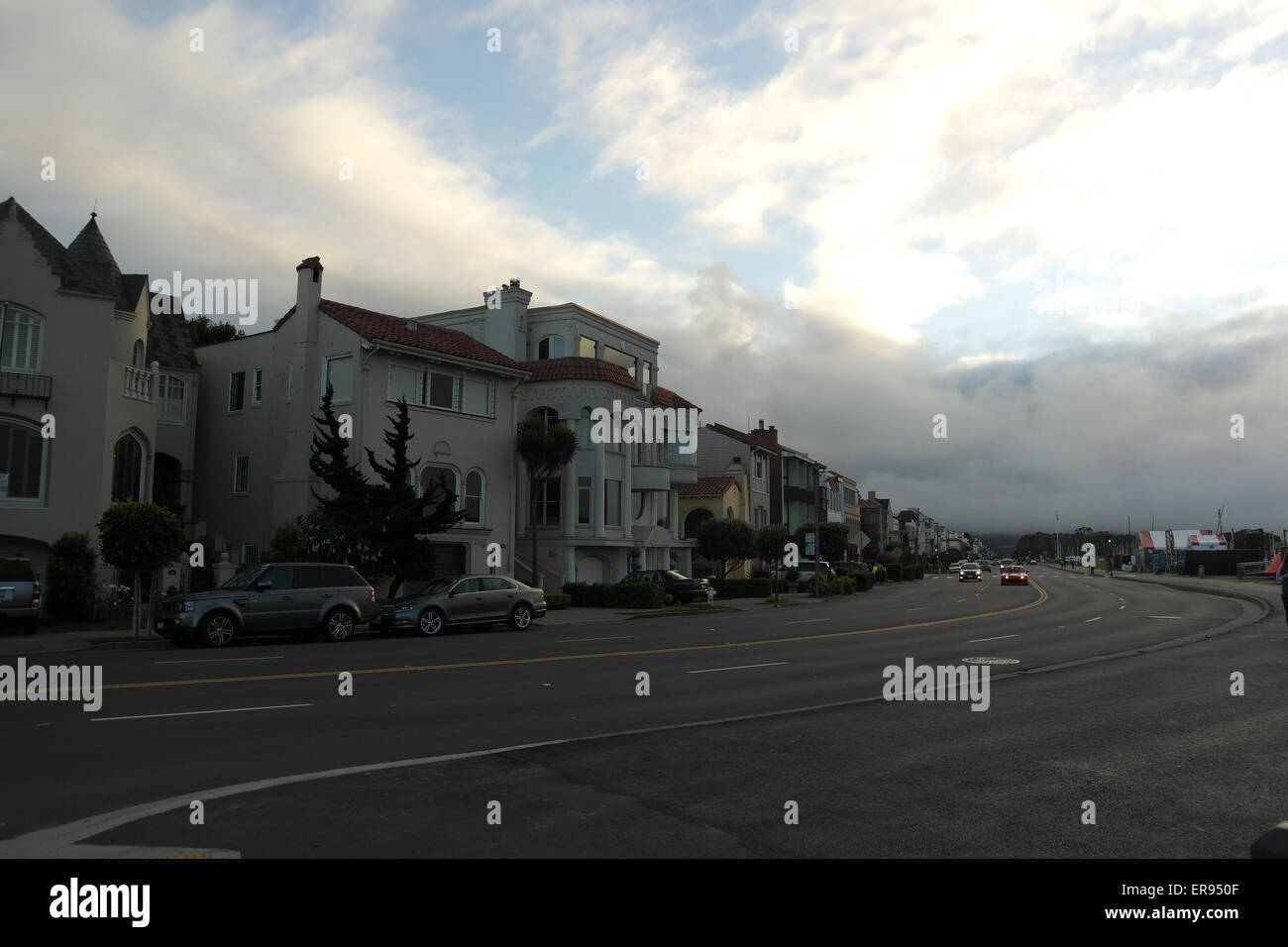 Grey white clouds sunset waterfront view, looking west, houses, cars, Marina Boulevard at Marina Green Drive, San Francisco, USA Stock Photo