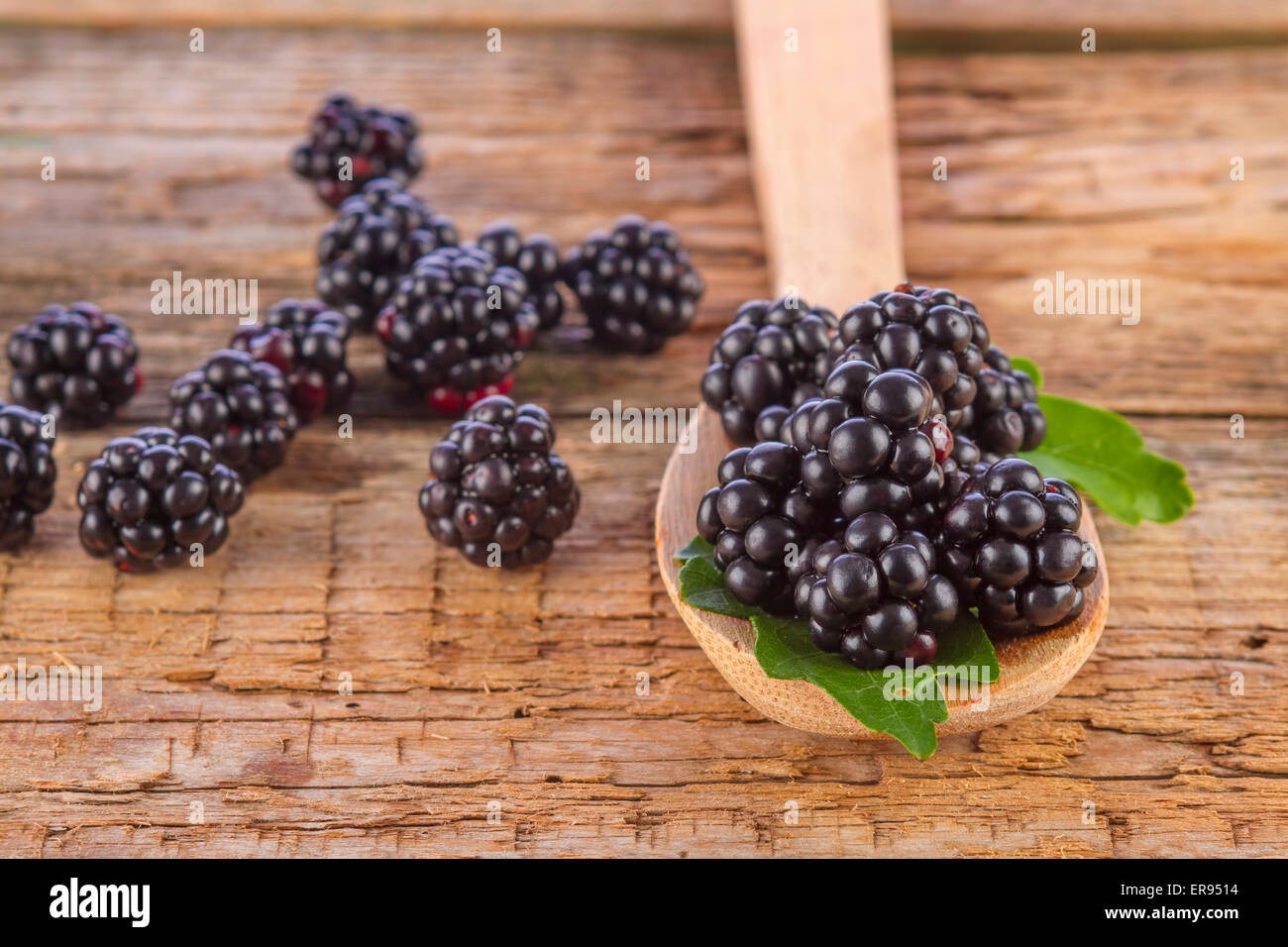 spoon of blackberries on wooden background closeup shot Stock Photo