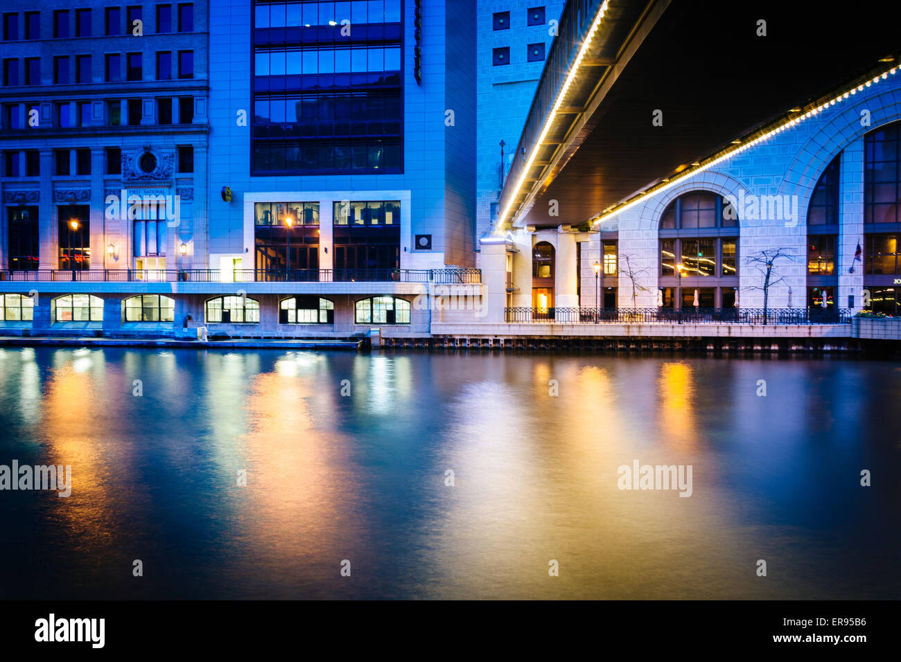 Buildings and pedestrian bridge over the Milwaukee River at night, in Milwaukee, Wisconsin Stock