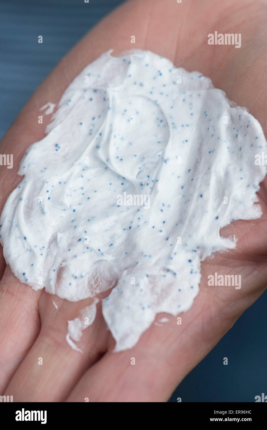 Womans hand holding a facial scrub product with Plastic microbeads Stock Photo