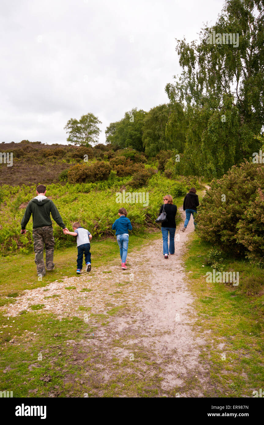 Rear View Of A family Walking Along A Track Together Through The Countryside Stock Photo