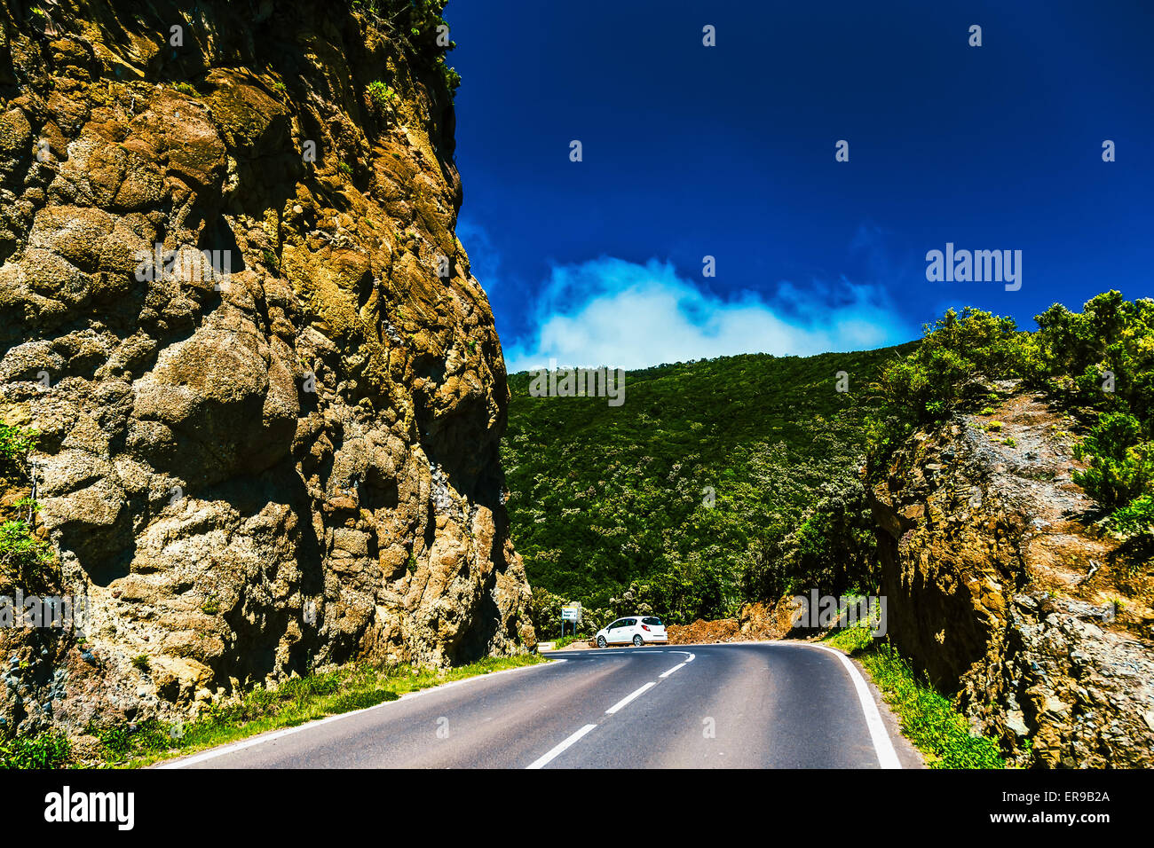 Asphalt road in green mountains with blue sky and clouds in Tenerife Canary island, Spain at spring or summer Stock Photo