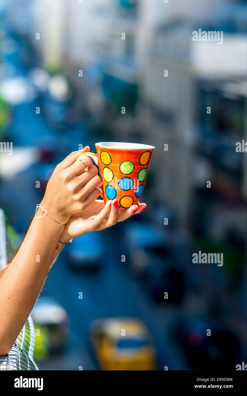 Holding colorful coffee cup on blured city background Stock Photo