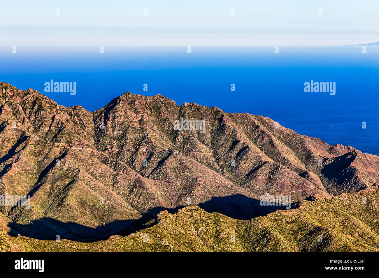 Coast of Atlantic ocean with green mountain or rock and blue sky with skyline in Tenerife Canary island, Spain at spring Stock Photo
