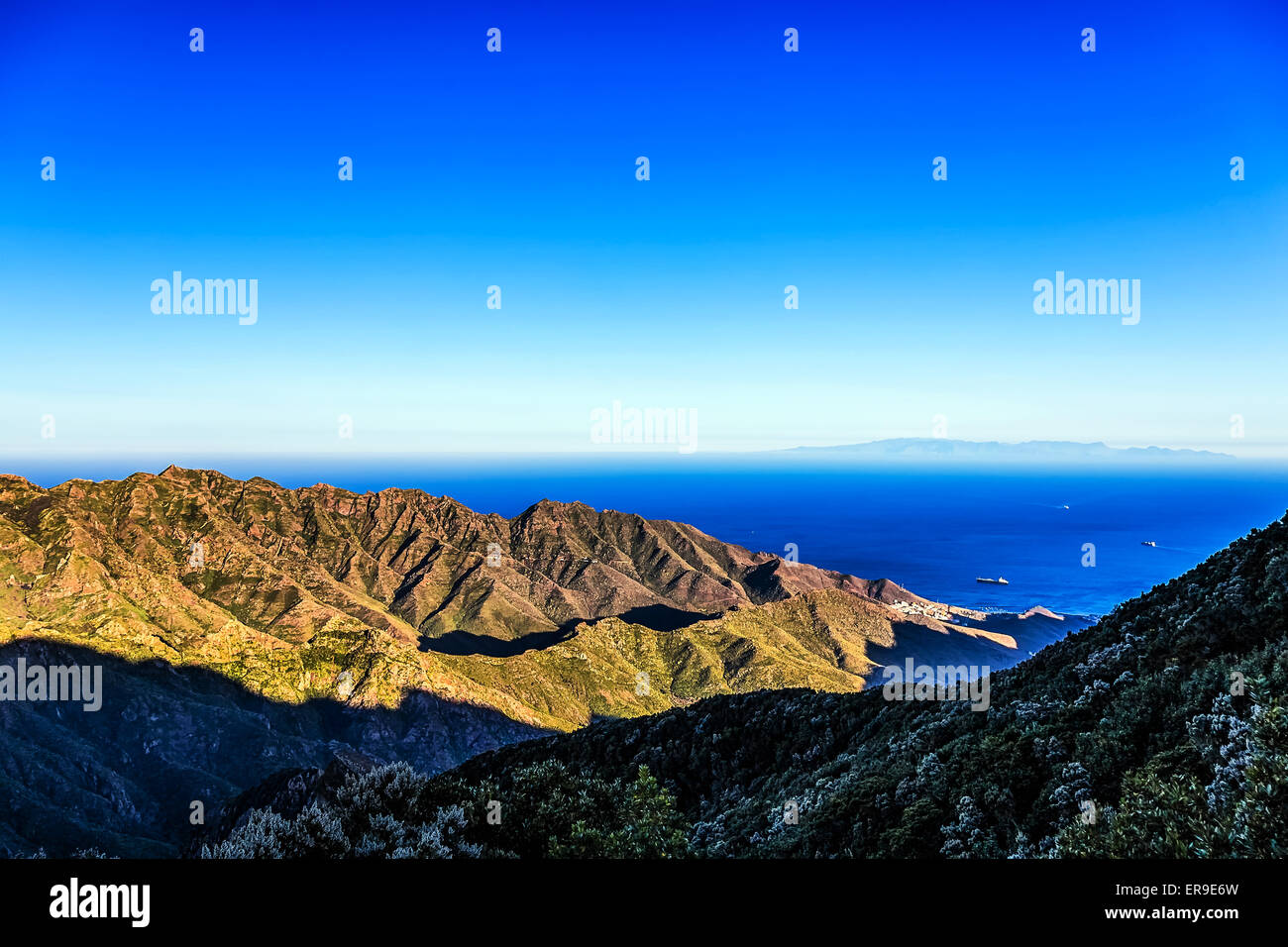 Coast of Atlantic ocean with green mountain or rock and  sky with skyline or horizon in Tenerife Canary island, Spain at spring Stock Photo