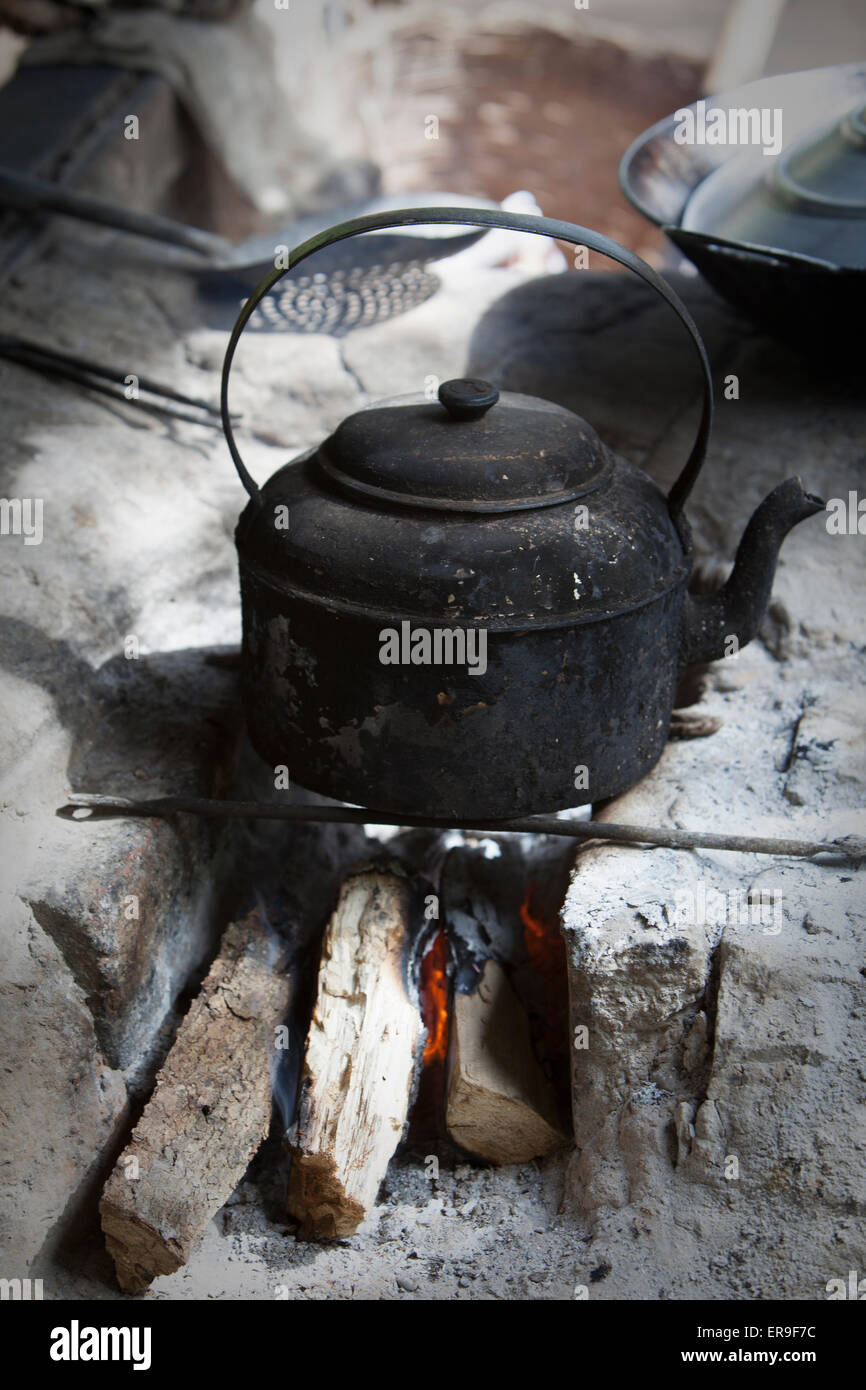 https://c8.alamy.com/comp/ER9F7C/a-smoked-black-kettle-set-over-burning-wood-on-a-crude-stone-hearth-ER9F7C.jpg