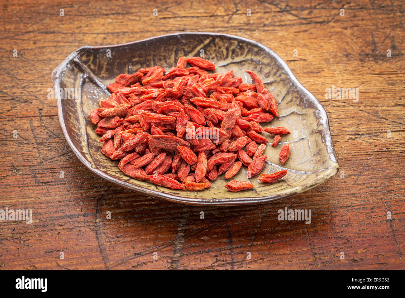 dried goji berries (wolfberry in a leaf shaped ceramic bowl against