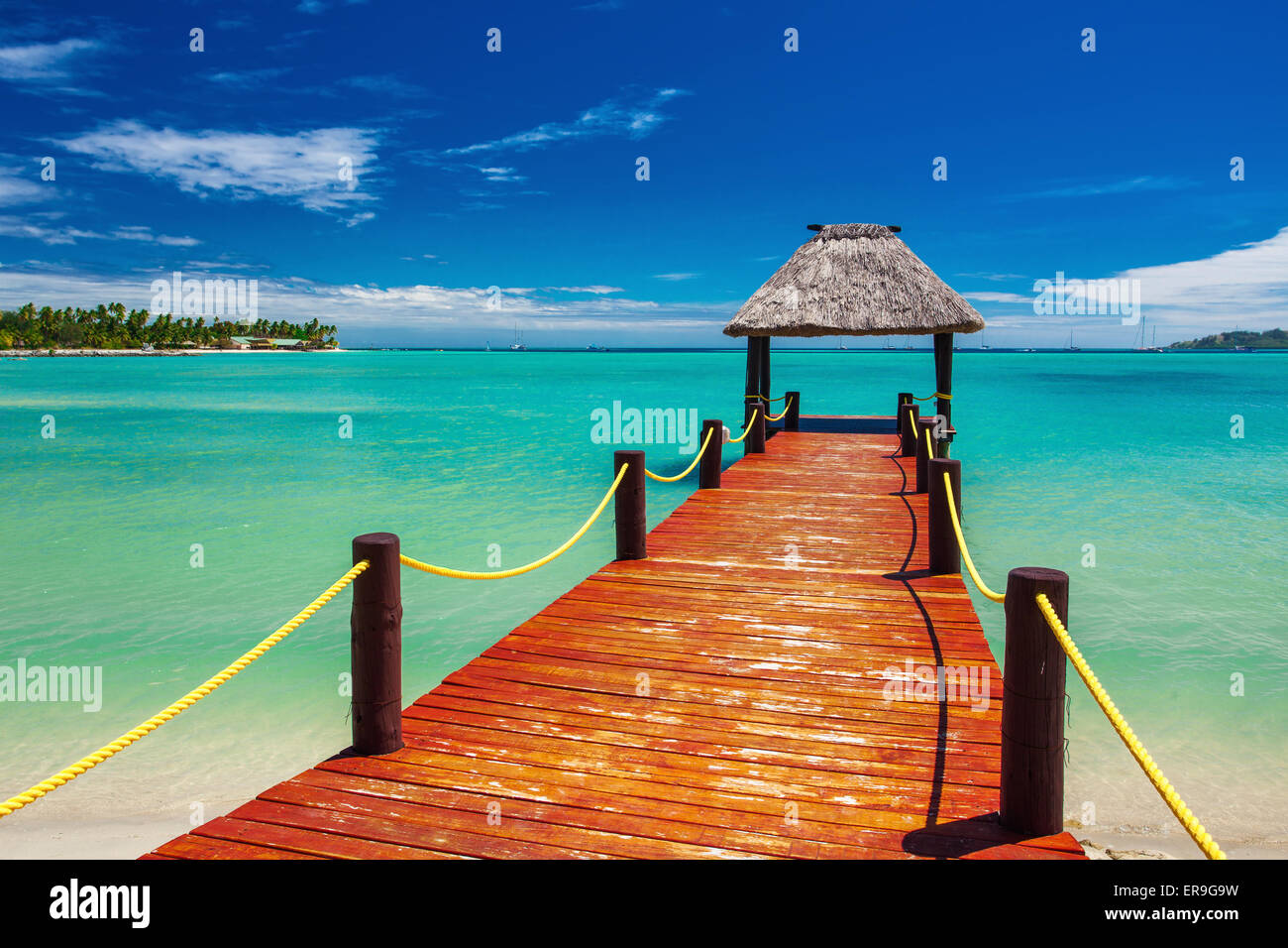 Short red wooden jetty extending to tropical ocean on Fiji Island Stock ...