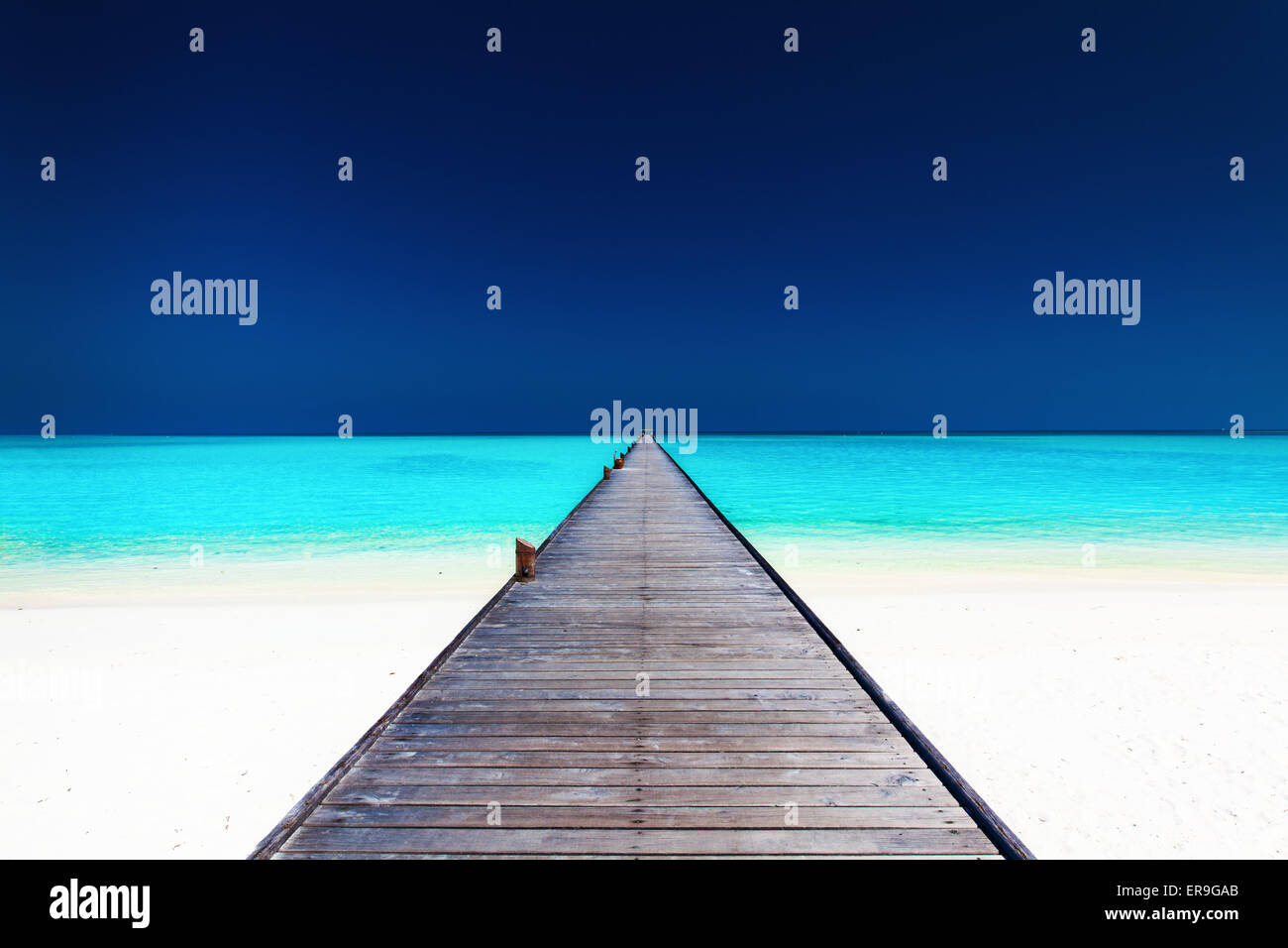 Wooden long jetty over lagoon with amazing clean azure water Stock Photo