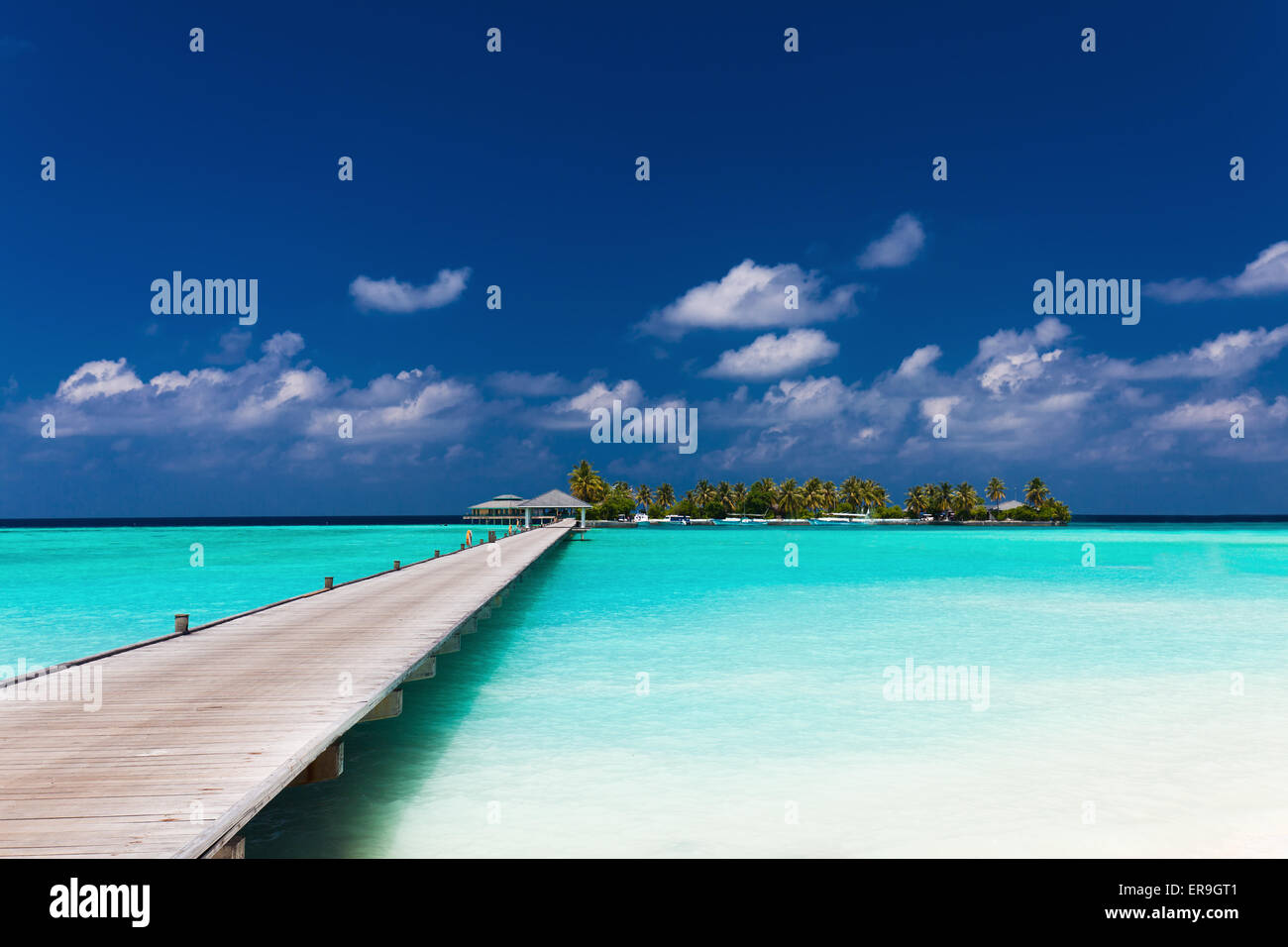 Wooden jetty to a tropical island over amazing lagoon in Maldives Stock ...