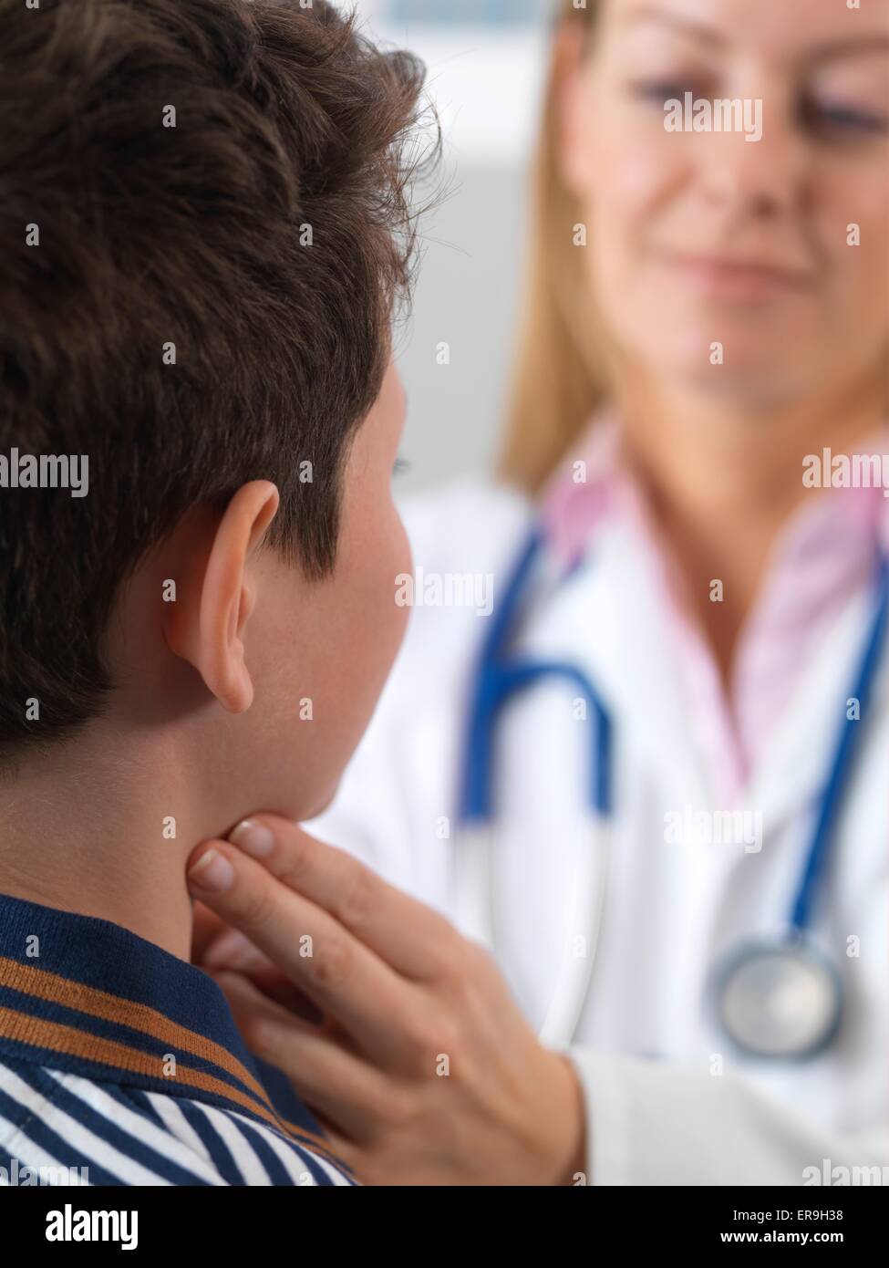 PROPERTY RELEASED. MODEL RELEASED. Doctor checking 10 year old boys glands as part of a medical examination. Stock Photo