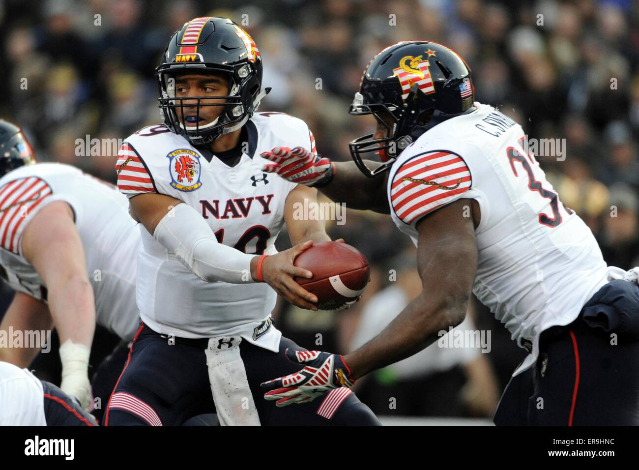 US Navy quarterback Keenan Reynolds hands a ball off to Chris Swan during the 115h Army-Navy football game at M&T Stadium December 13, 2014 in Baltimore, Maryland. Navy beat Army 17-10, extending their winning streak against Army for the 13th straight year. Stock Photo