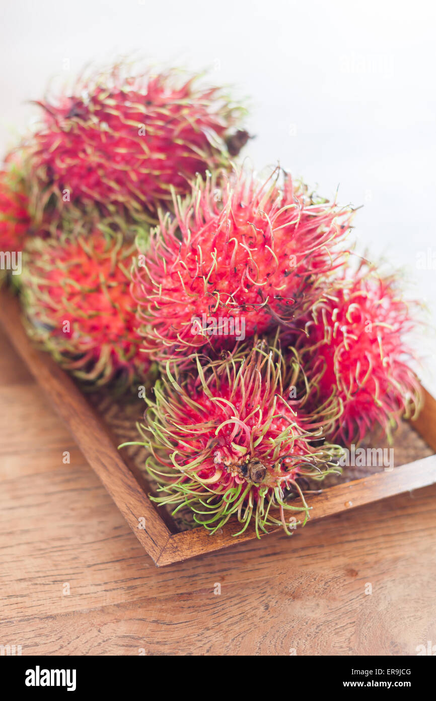 Fresh rambutans on wooden tray, stock photo Stock Photo