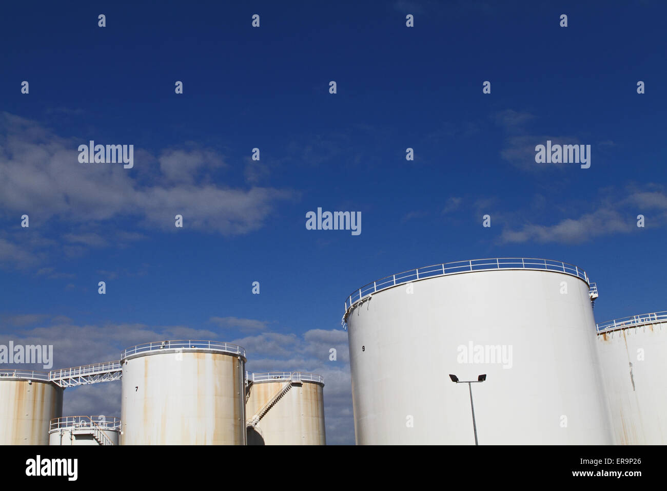 Oil containers against a blue sky Stock Photo