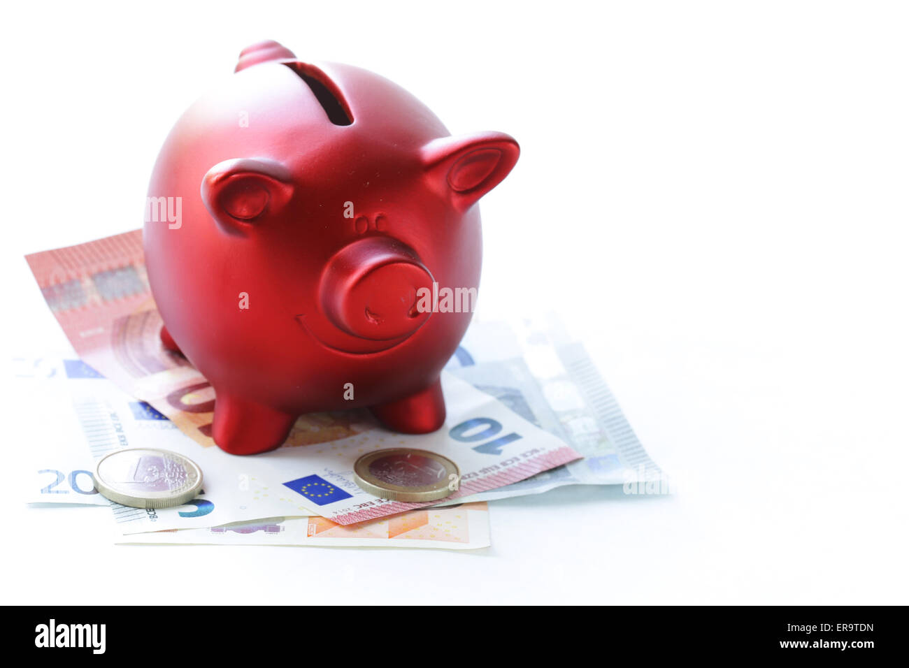 red piggy bank with euro banknotes and coins Stock Photo - Alamy