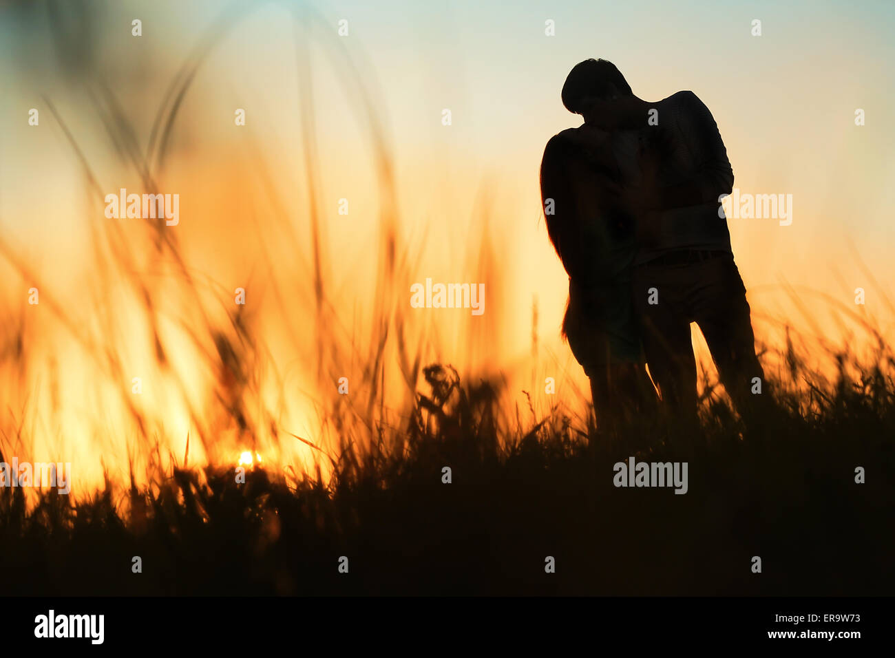 silhouette of a young couple kissing at sunset Stock Photo - Alamy