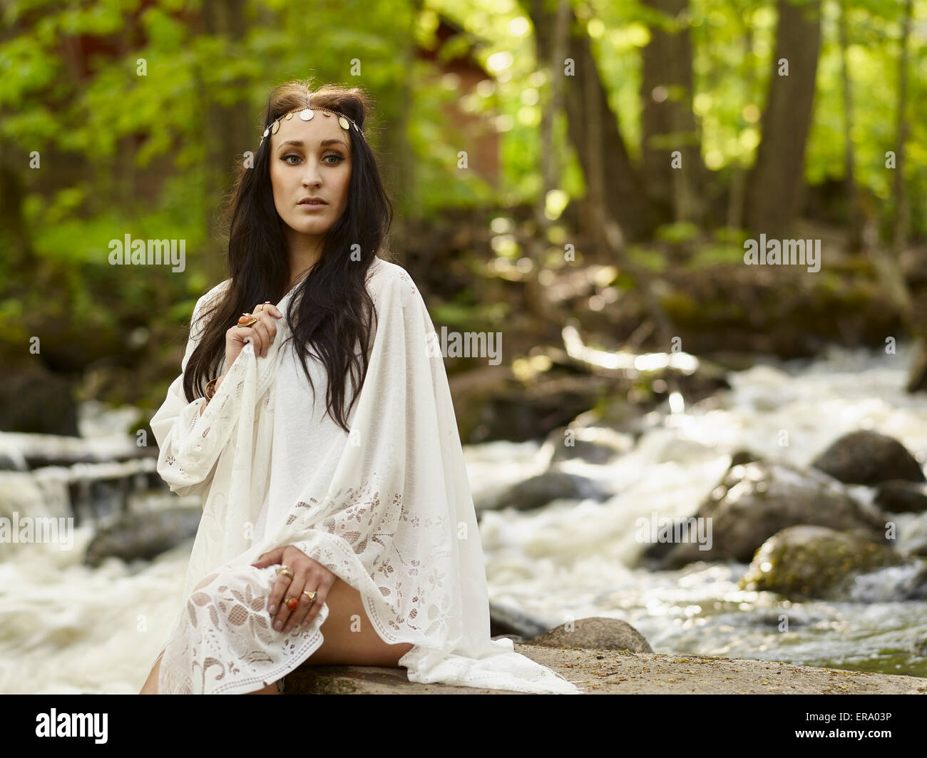 Beautiful brunette woman alone on a river, white dress Stock Photo - Alamy