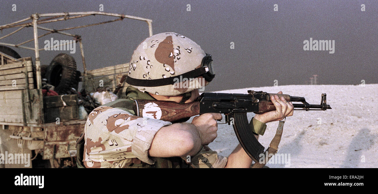 5th March 1991 A coalition soldier fires an Iraqi AK-47 Kalashnikov rifle into the desert on the road to Umm Qasr in Kuwait. Stock Photo