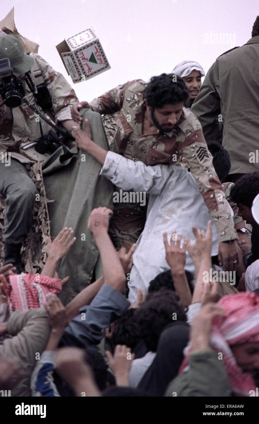 23rd March 1991 Saudi Arabian soldiers distribute food and drink to desperate Shia Iraqis near Safwan, close to the border with Kuwait. Stock Photo