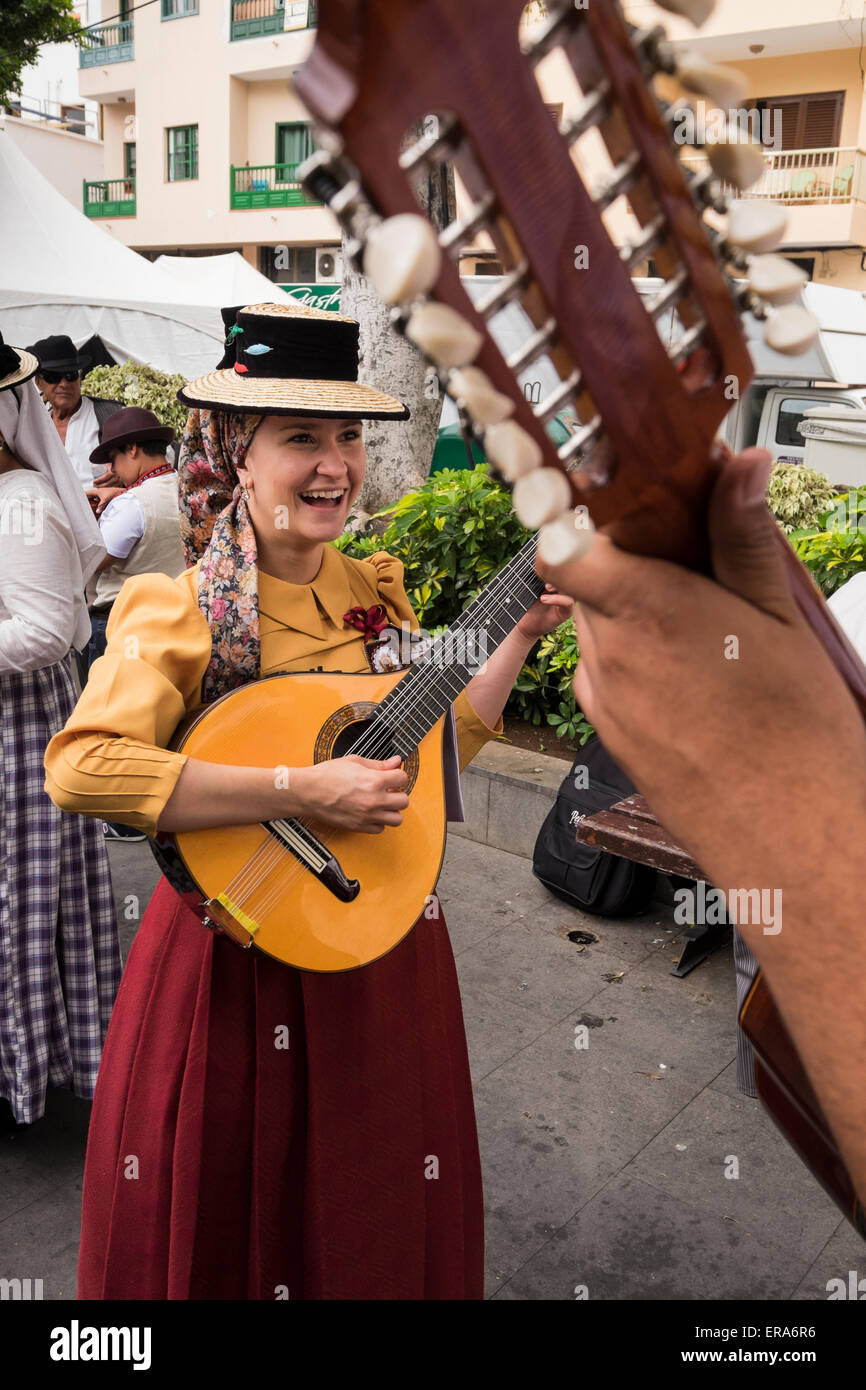 Woman laughing whilst playing stringed instrument at the annual Dia de Canarias festival in Alcala, tenerife, Canary Islands, Spain Stock Photo