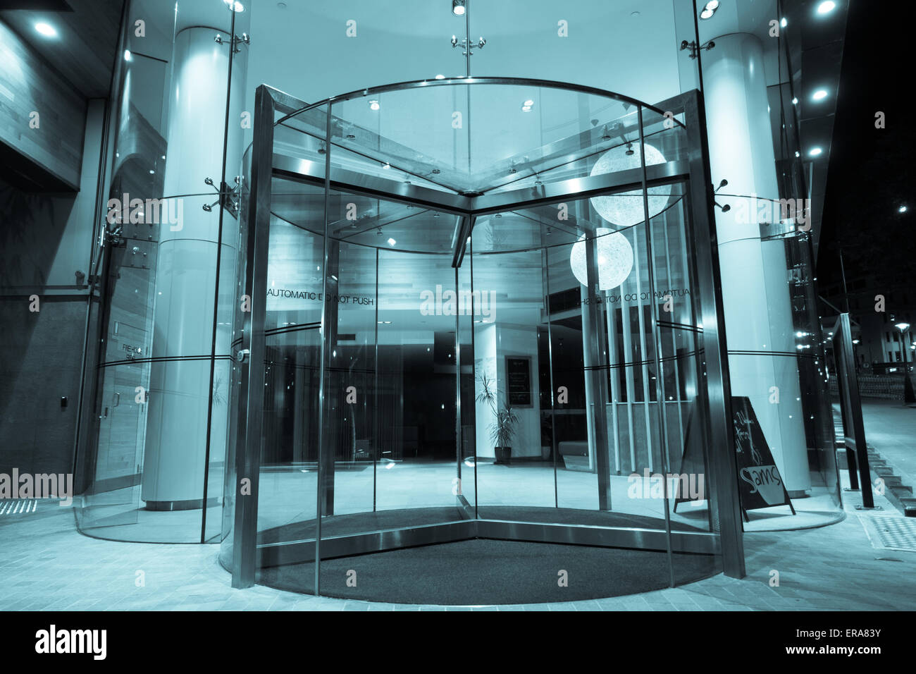 Glass revolving door in building foyer Stock Photo - Alamy