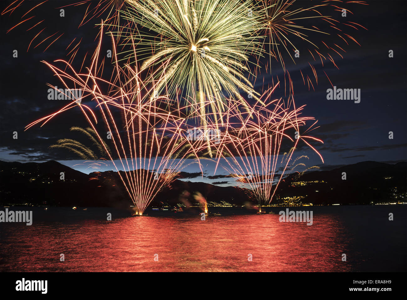 Lakefront Luino fireworks on the Maggiore lake in summer evening, Lombardy - Italy Stock Photo