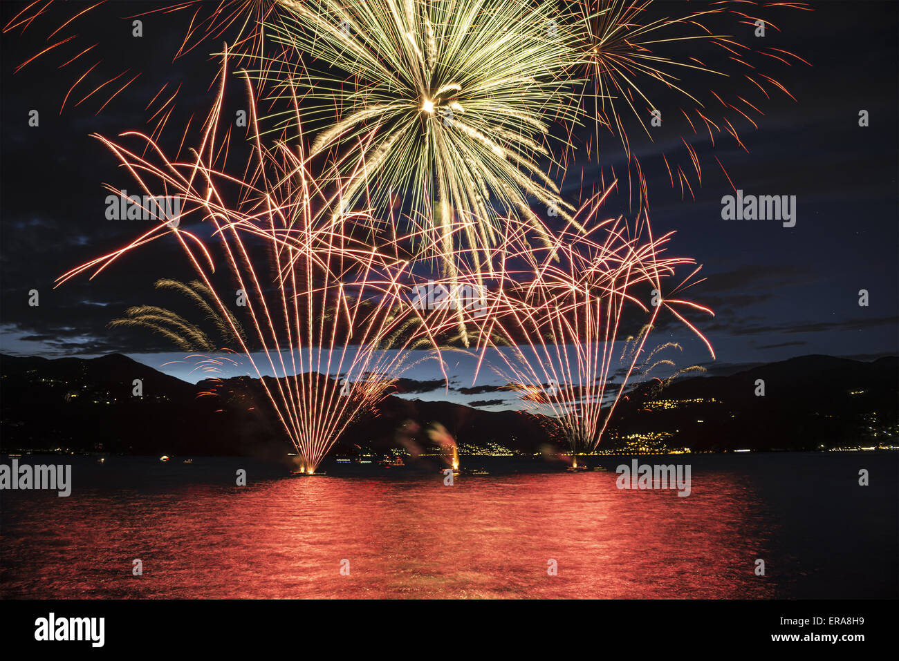 Lakefront Luino fireworks on the Maggiore lake in summer evening