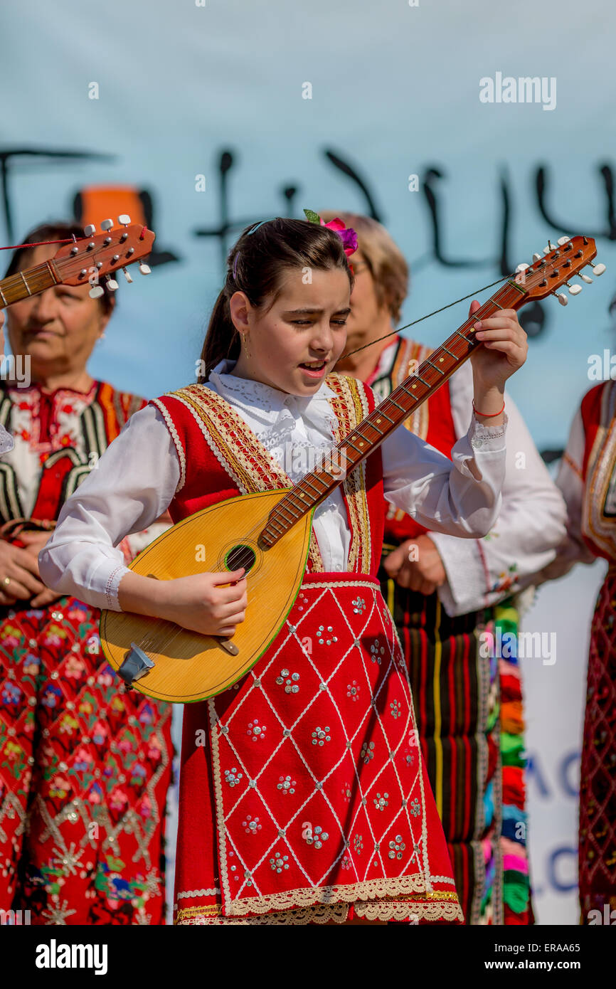 A young female Bulgarian folklore musician playing bouzouki during the